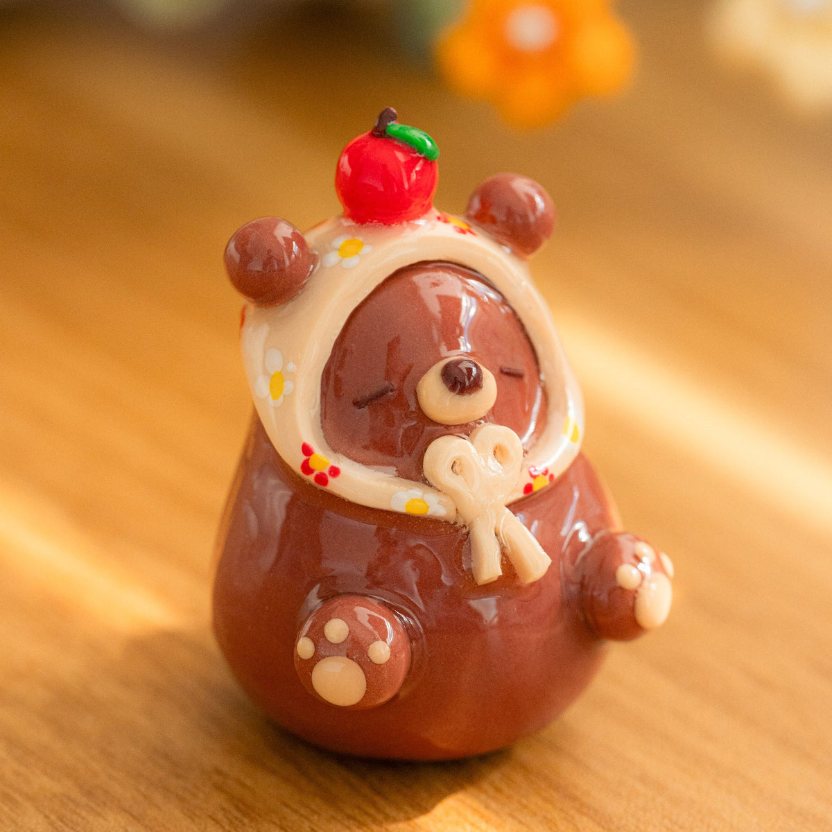 A cozy bear figurine with a babushka scarf made from polymer clay.